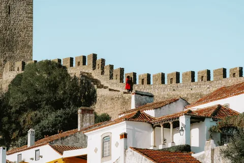 Obidos's historic walls and whitewashed buildings under a clear summer sky.