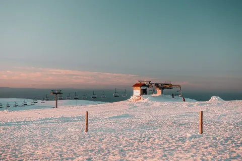 Serene winter landscape of a ski lift at Serra da Estrela, Portugal during sunset.