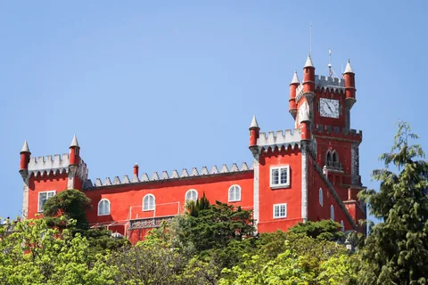 Stunning view of the vibrant red castle in Sintra, Portugal under a clear blue sky.